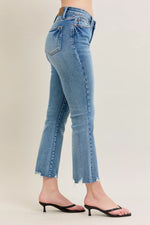 Blue jeans worn by a person on a plain background