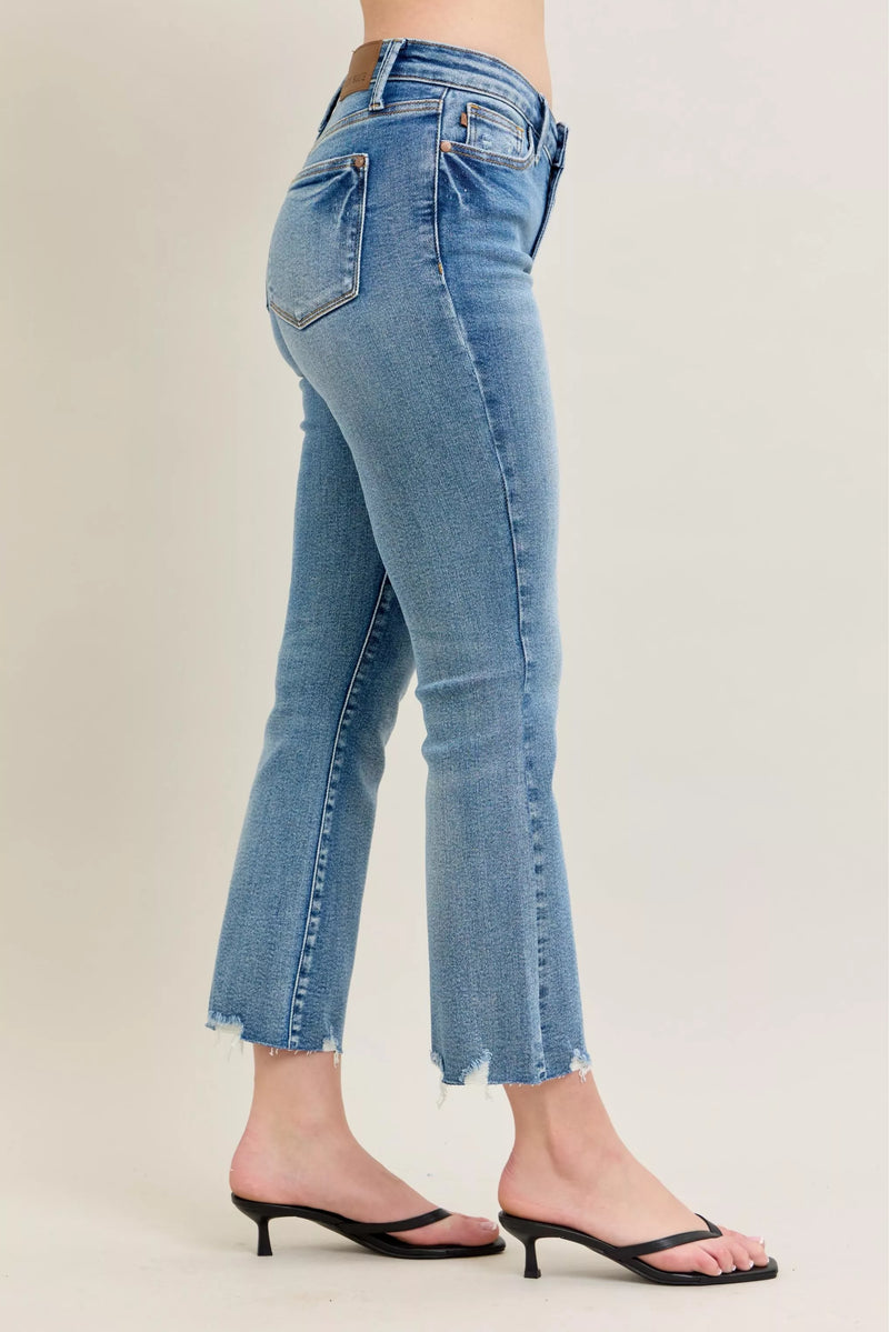 Blue jeans worn by a person on a plain background