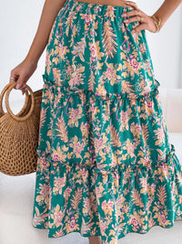 Person wearing a green floral skirt with a woven handbag on a white background