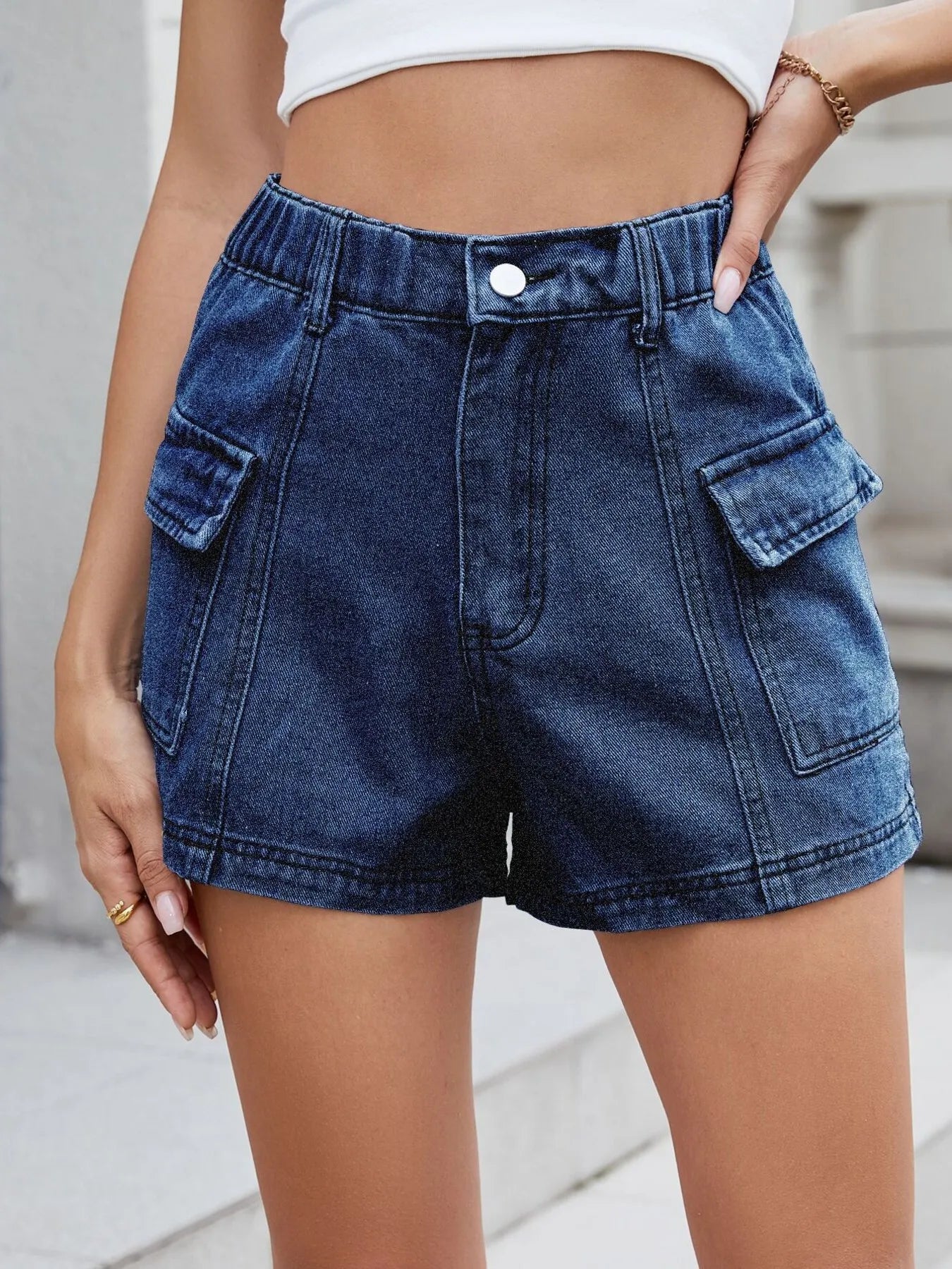 Blue denim shorts worn by a person on a neutral background
