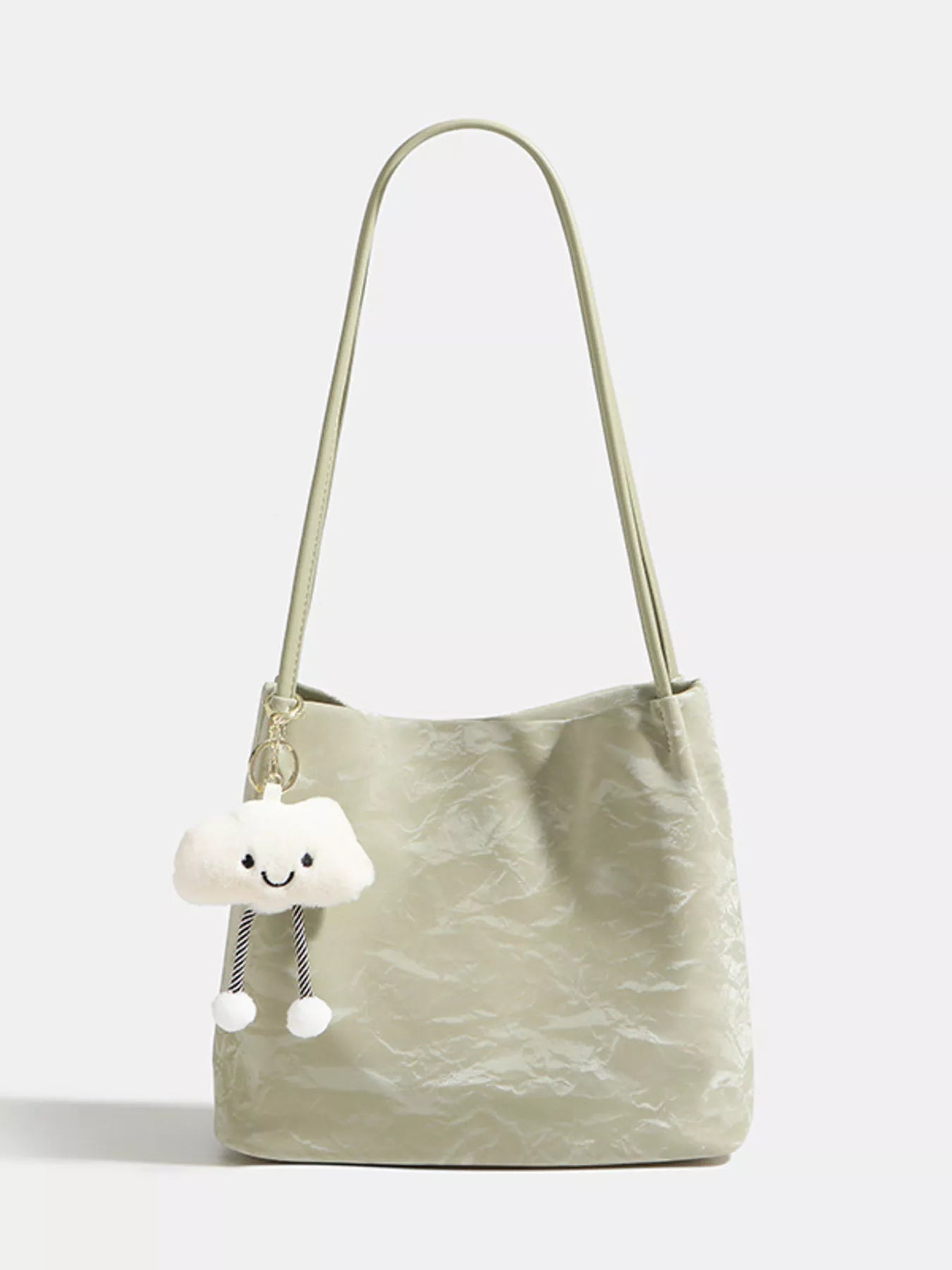 Light green handbag with a cloud-shaped charm on a white background