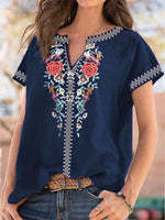 Navy blue embroidered blouse worn by a person with a blurred background