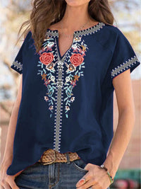 Navy blue embroidered blouse worn by a person with a blurred background