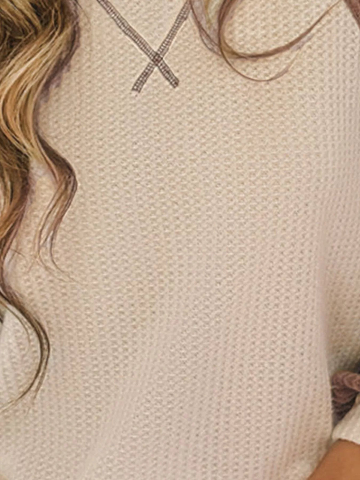 Close-up of a textured beige fabric with wavy hair on top