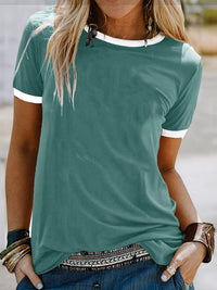 Person wearing a green t-shirt with white trim in an outdoor setting
