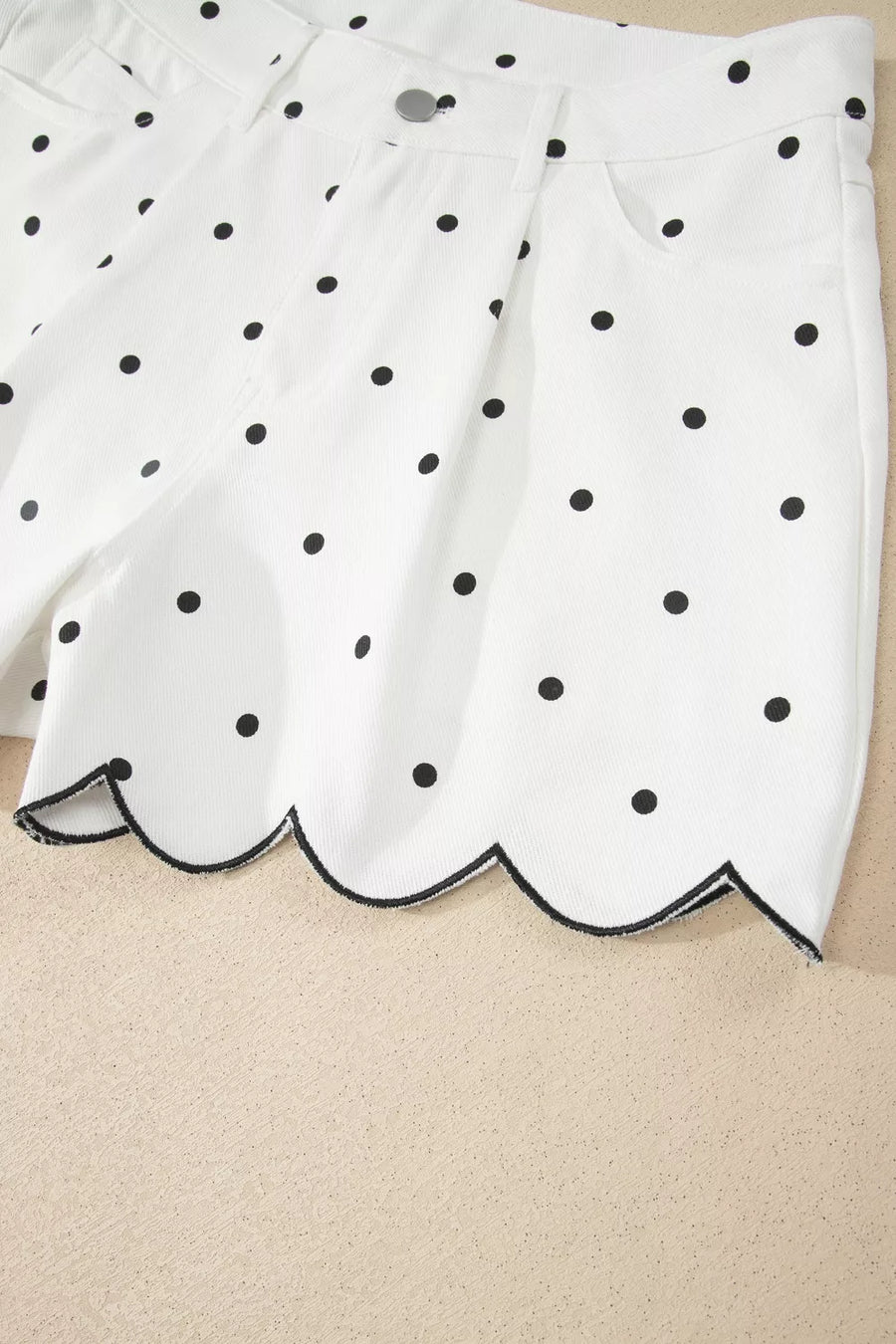 White skirt with black polka dots on a beige background