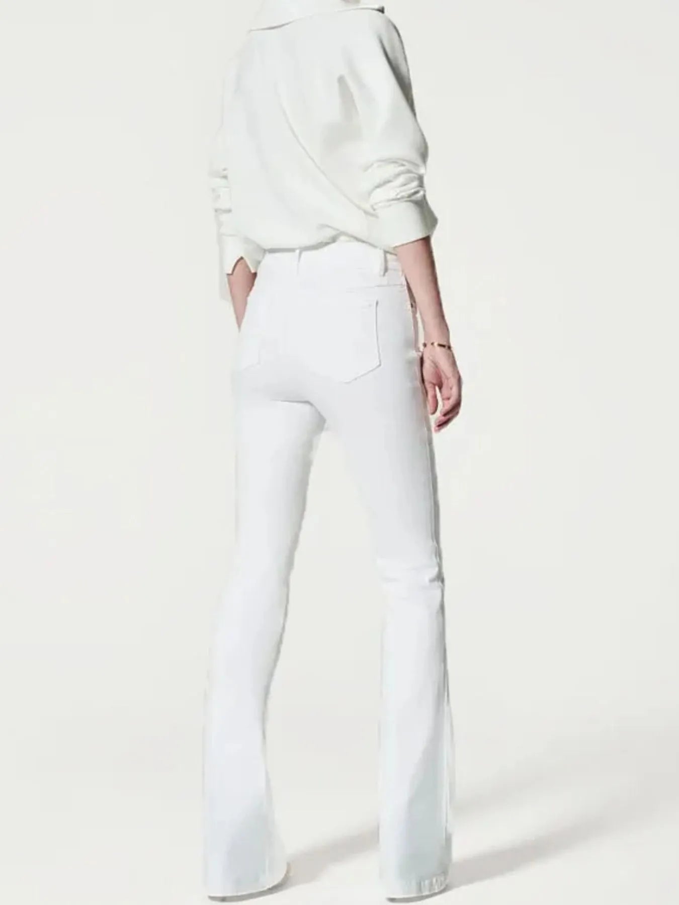 Person wearing a white sweatshirt and white pants on a white background