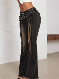 Black flared jeans with decorative elements on a white background