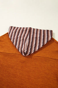 Brown sweater with a patterned collar against a white background