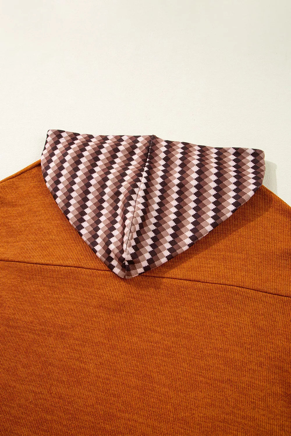 Brown sweater with a patterned collar against a white background