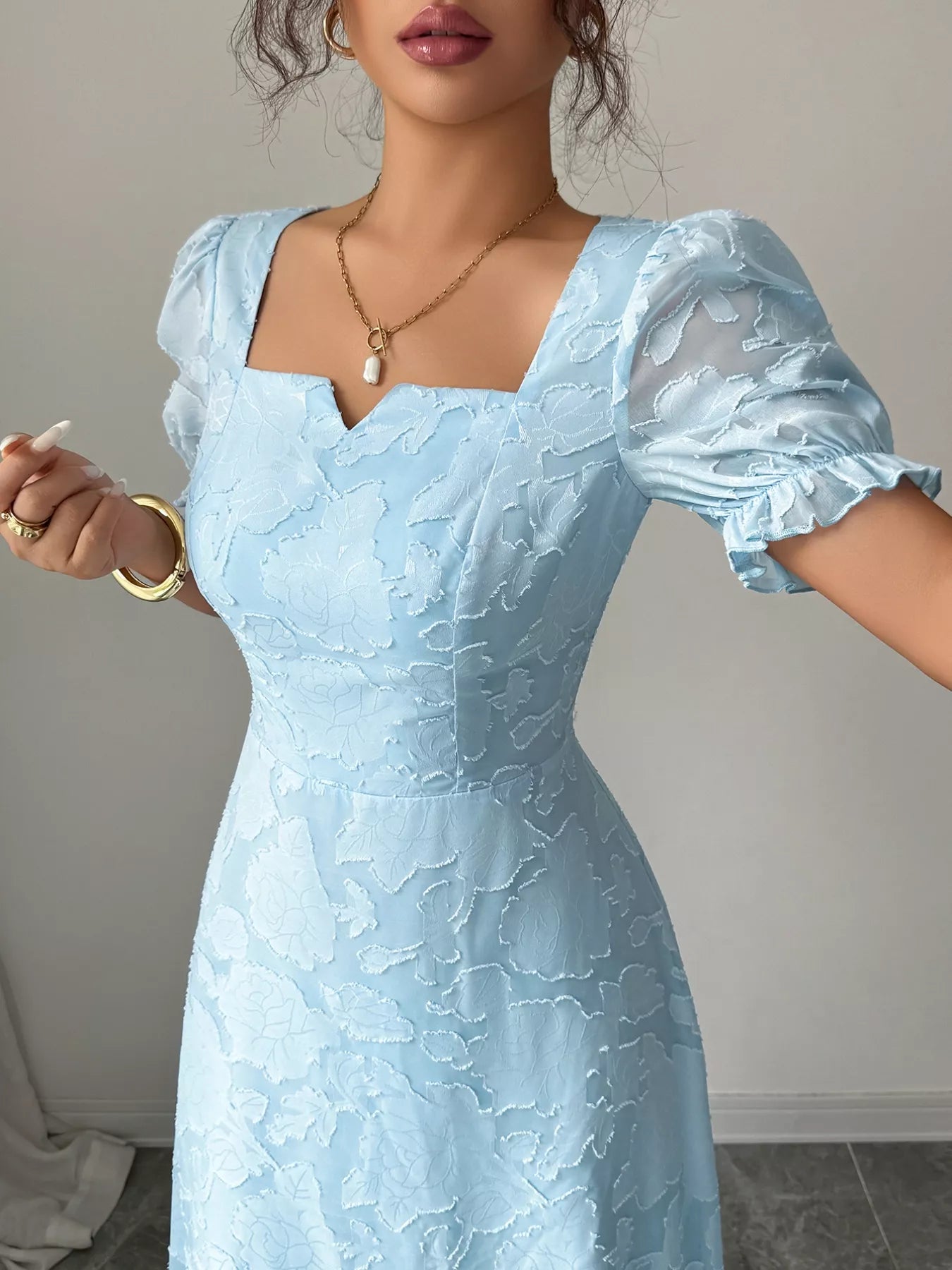Light blue lace dress worn by a person against a neutral background
