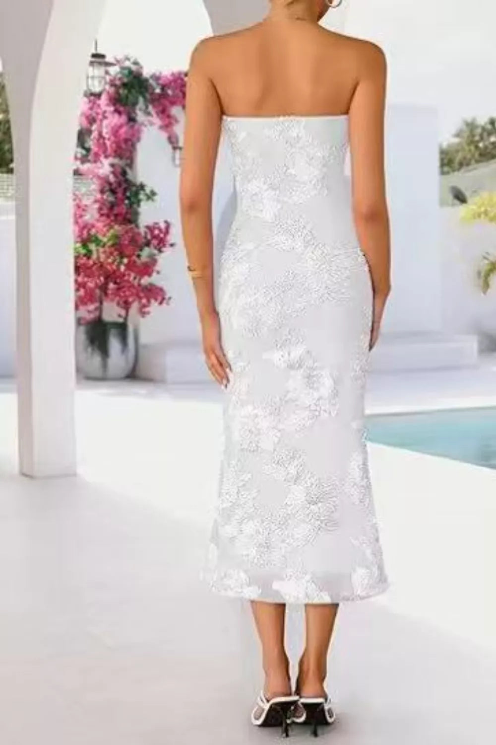 Woman wearing a strapless white sequin dress with a blurred outdoor background