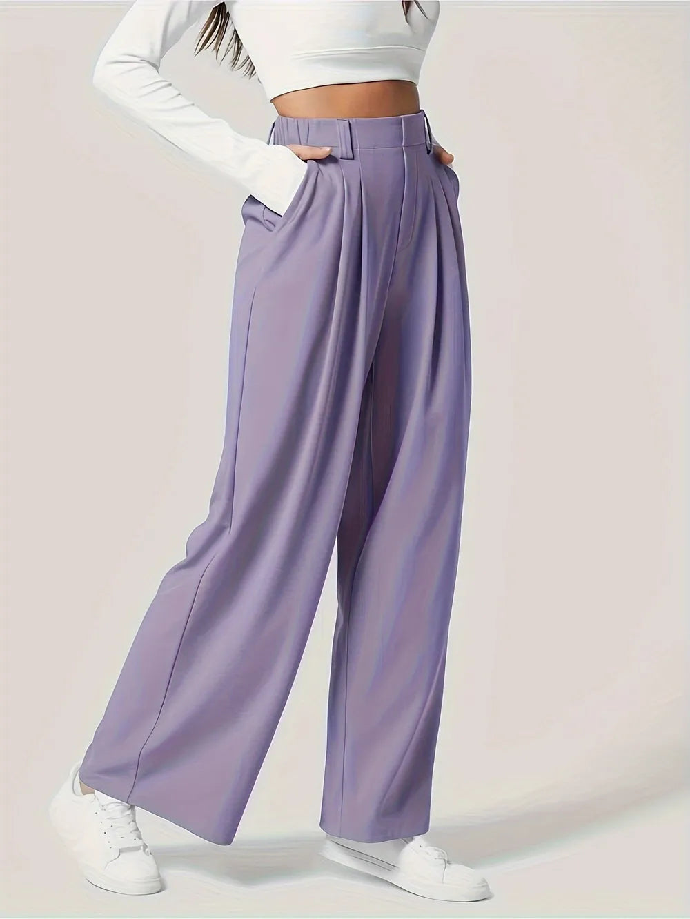 Person wearing lavender wide-leg pants with a white top on a light background
