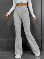 Person wearing gray ribbed knit pants against a dark background