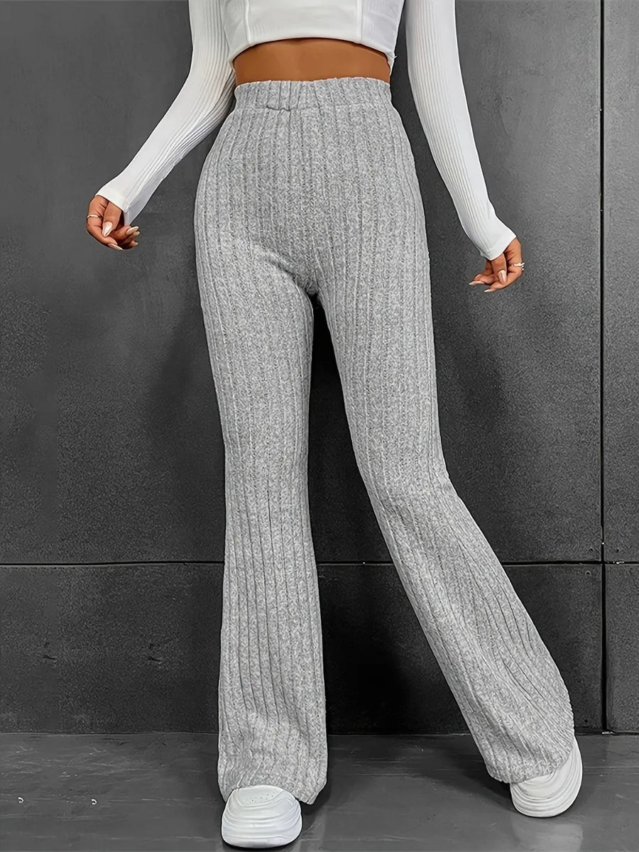 Person wearing gray ribbed knit pants against a dark background