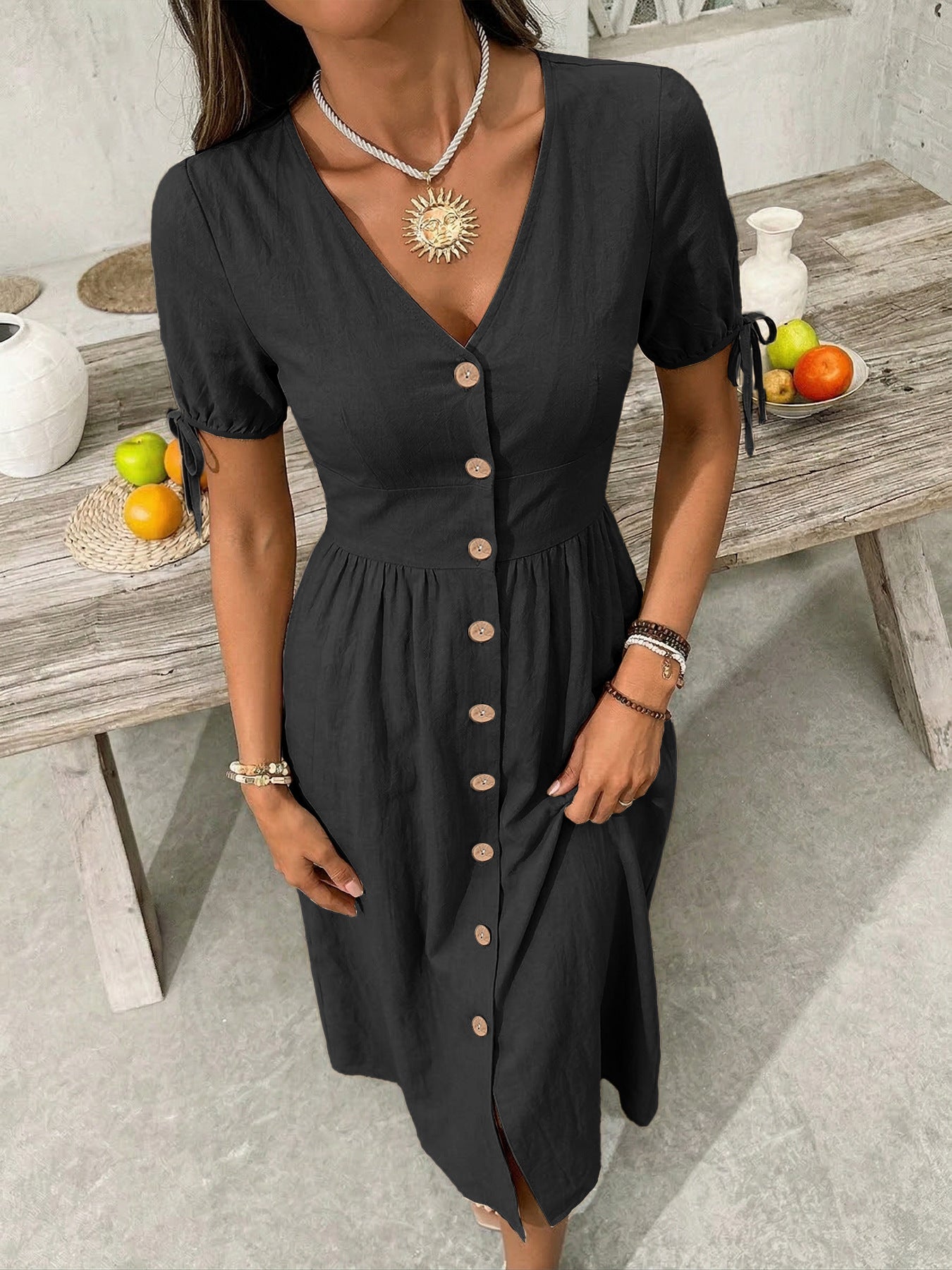Woman wearing a black dress with buttons in a casual setting