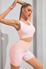 Woman wearing a pink athletic outfit against a light gray background