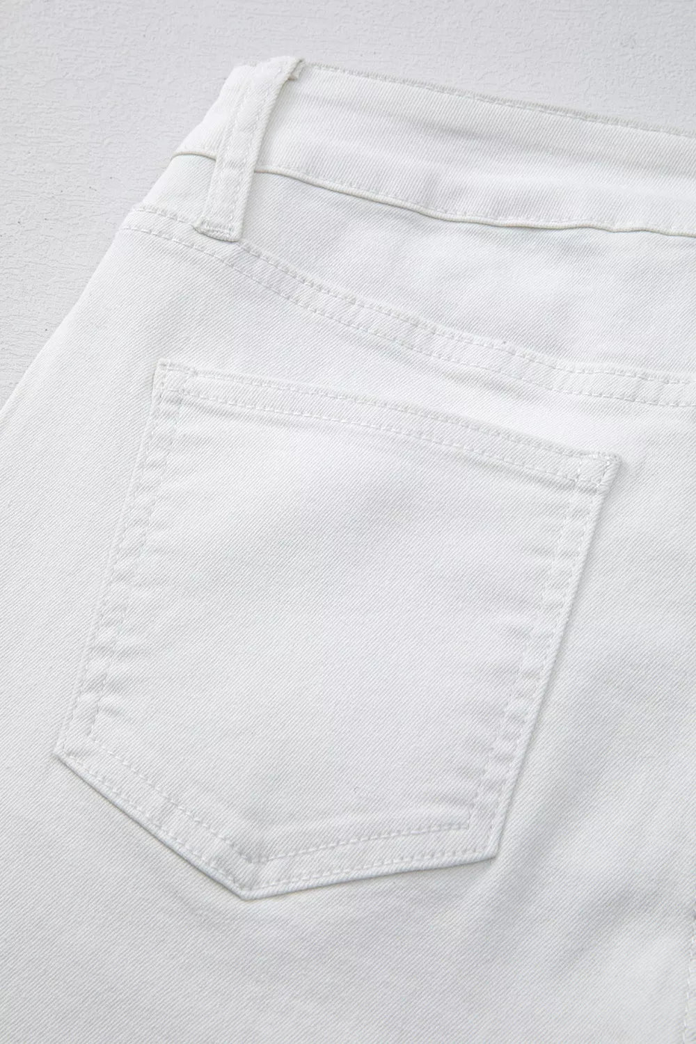 Close-up of a white pocket on light gray fabric