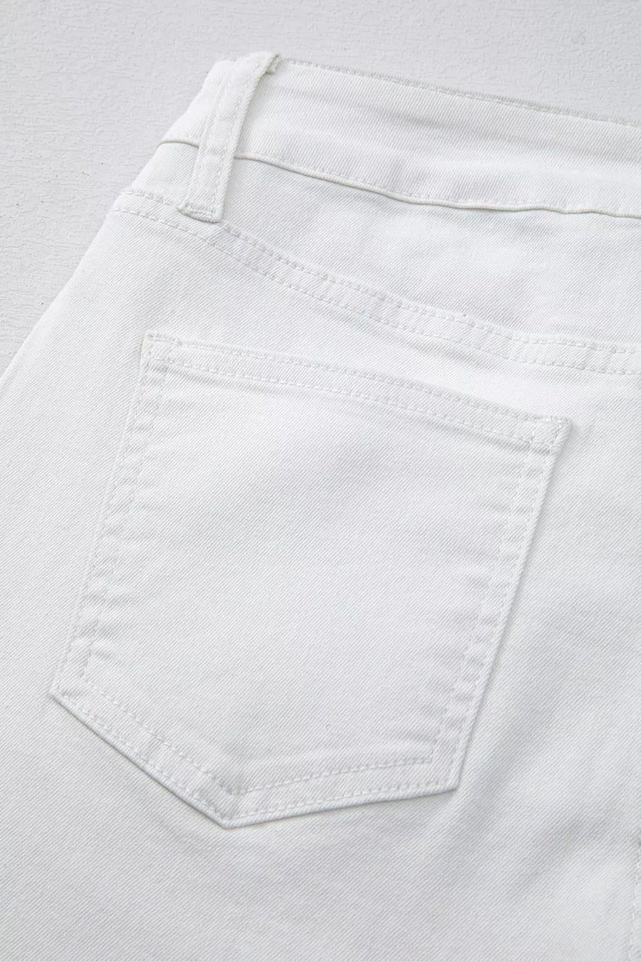Close-up of a white pocket on light gray fabric