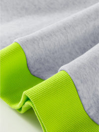Close-up of gray fabric with green trim on a light background