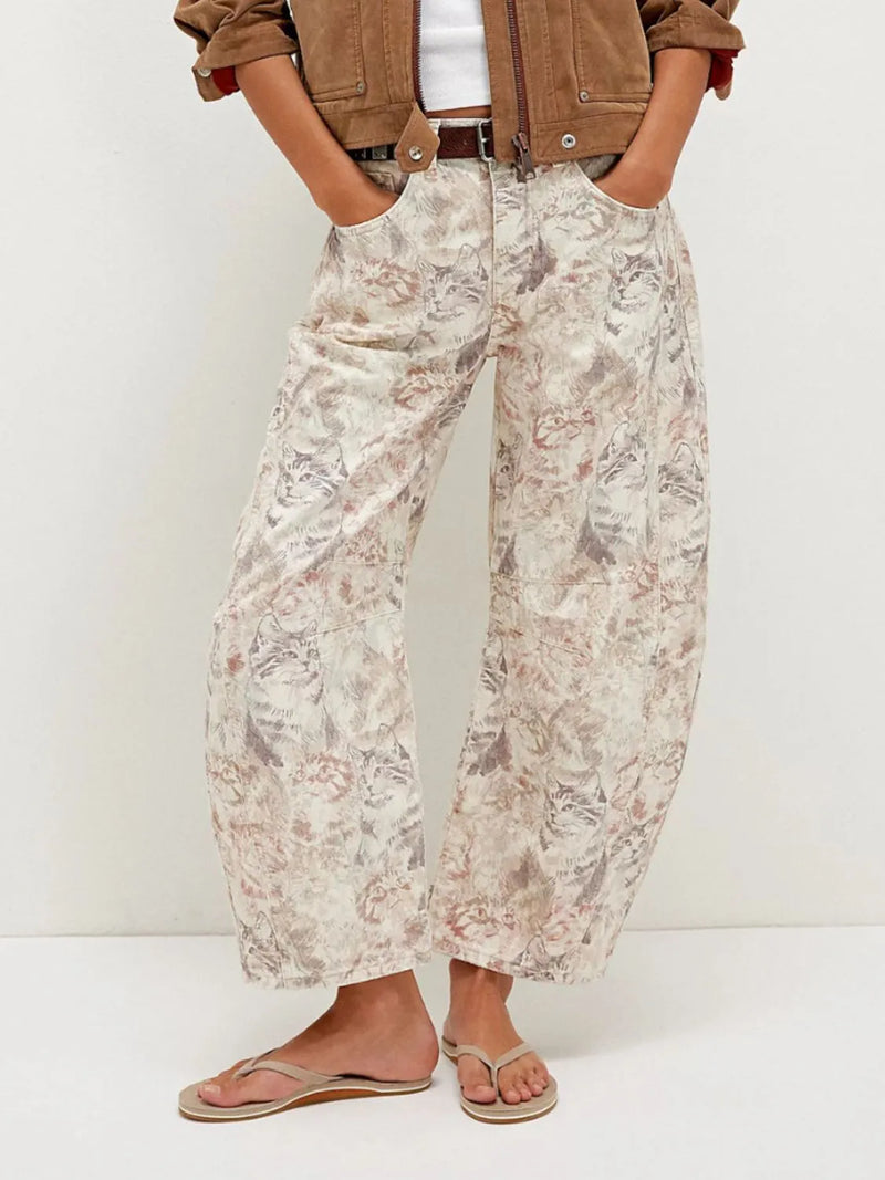 Person wearing floral pants and a brown jacket on a white background