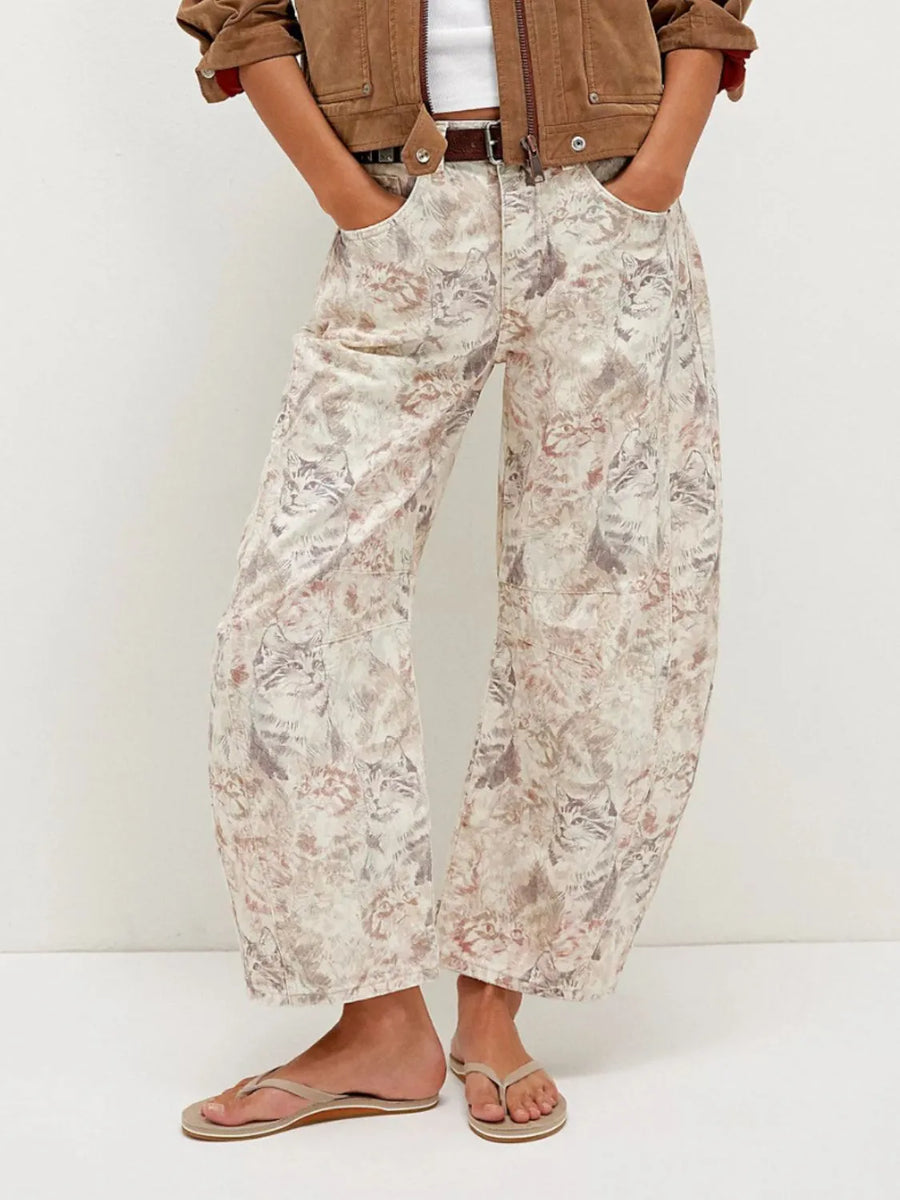 Person wearing floral pants and a brown jacket on a white background