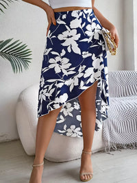 Person wearing a navy floral skirt in an indoor setting