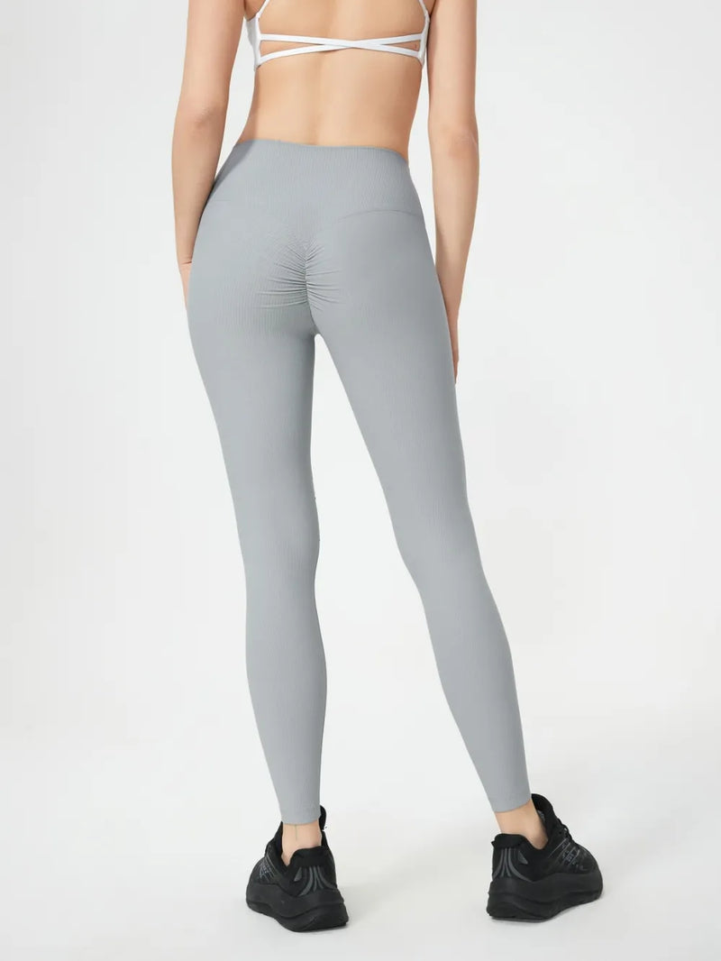 Person wearing gray leggings on a white background