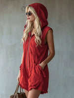 Woman wearing a red hooded dress against a plain background
