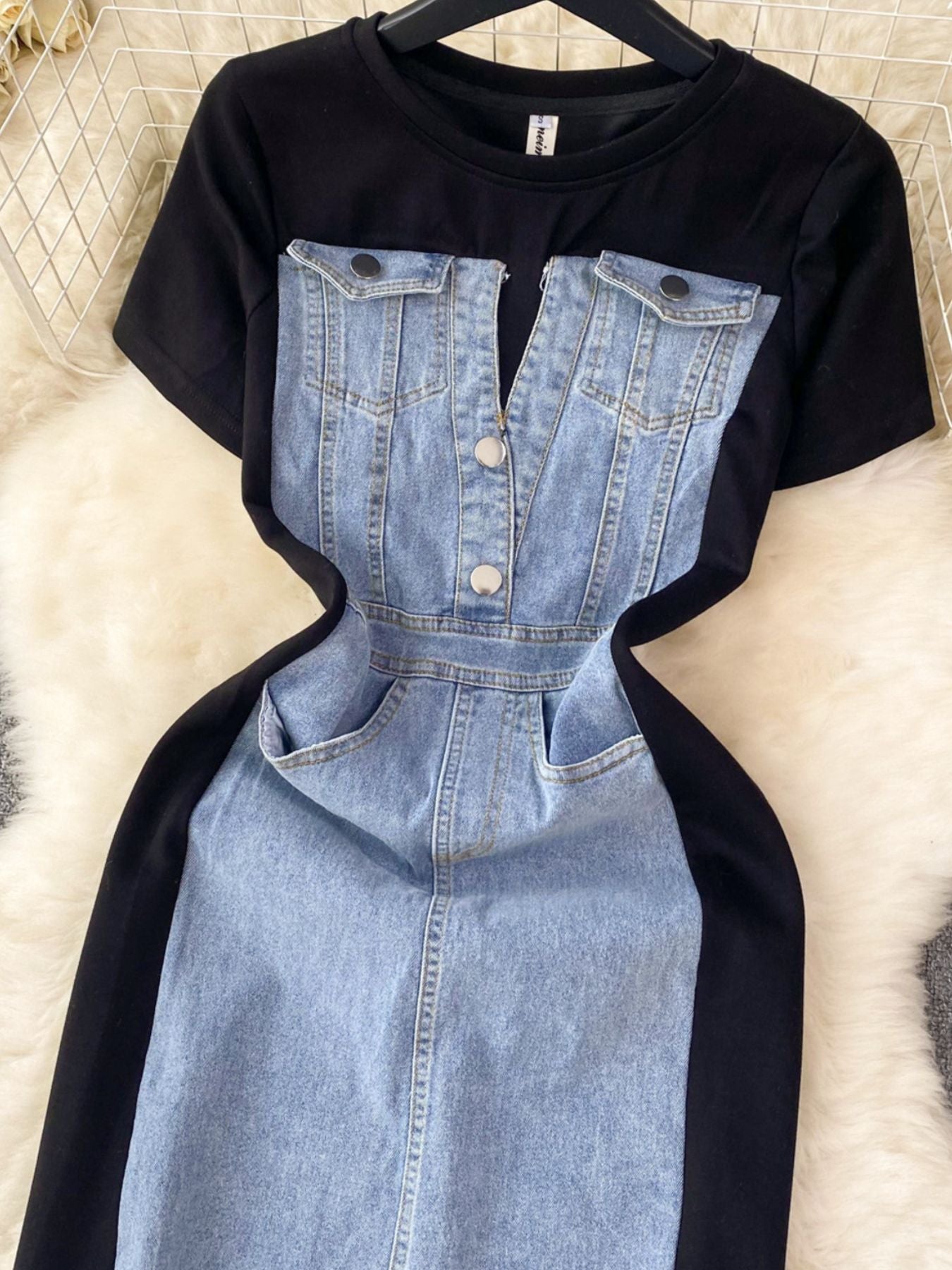 Black t-shirt with denim overalls on a textured surface
