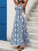 Woman wearing a blue and white patterned dress standing on stone steps.