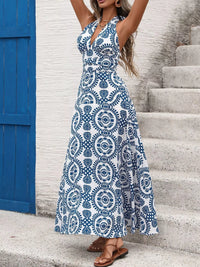 Woman wearing a blue and white patterned dress standing on stone steps.