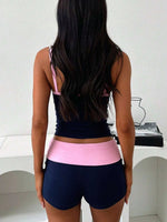 Person wearing a black and pink athletic outfit with a white background