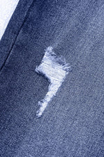 Close-up of a blue denim fabric with a distressed design.