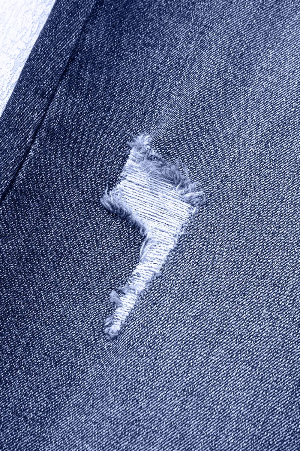 Close-up of a blue denim fabric with a distressed design.