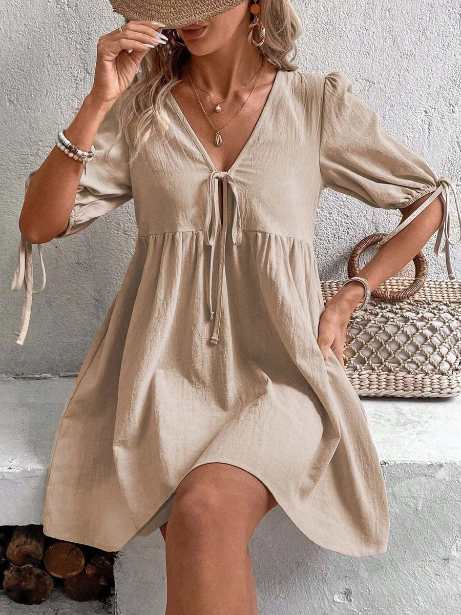 Woman wearing a beige dress with a neutral background