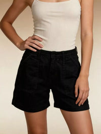 Person wearing a white tank top and black shorts on a beige background
