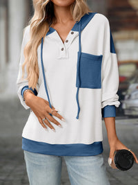 Woman wearing a white and blue striped sweater holding a coffee cup.