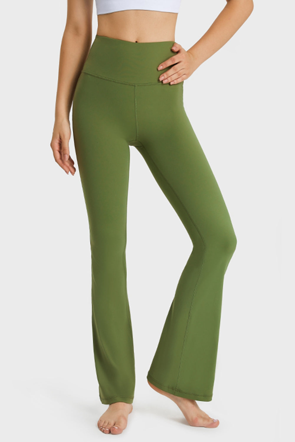Green yoga pants worn by a person on a white background