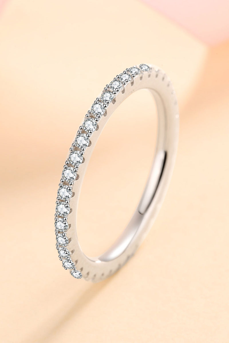 Silver ring with small diamonds on a peach background