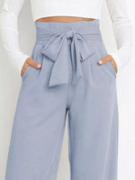 Light blue pants with a tie waist worn by a person on a white background