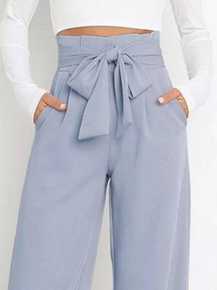 Light blue pants with a tie waist worn by a person on a white background