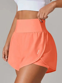 Person wearing a coral athletic skirt on a plain background