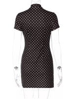 Black dress with white polka dots on a mannequin against a white background