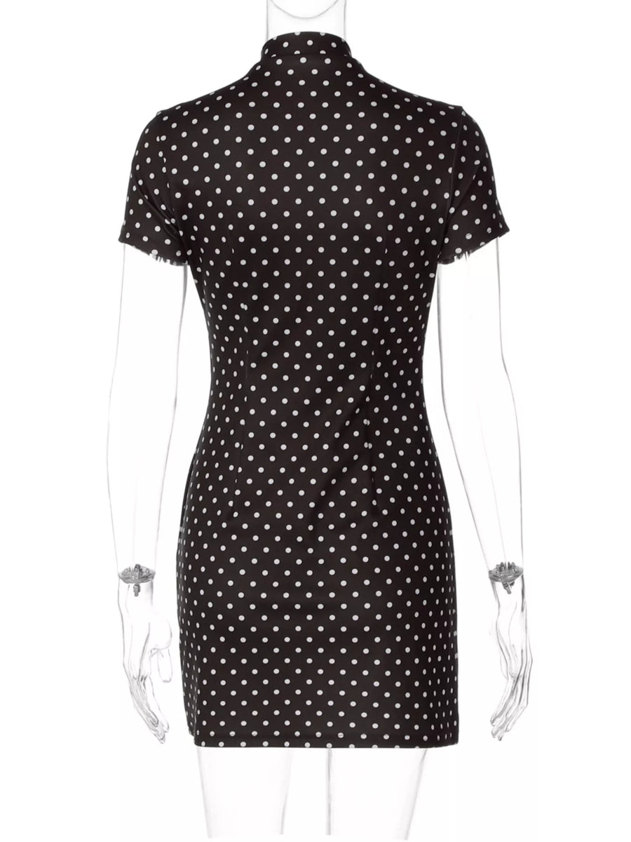 Black dress with white polka dots on a mannequin against a white background