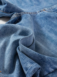 Close-up of blue denim fabric with visible stitching
