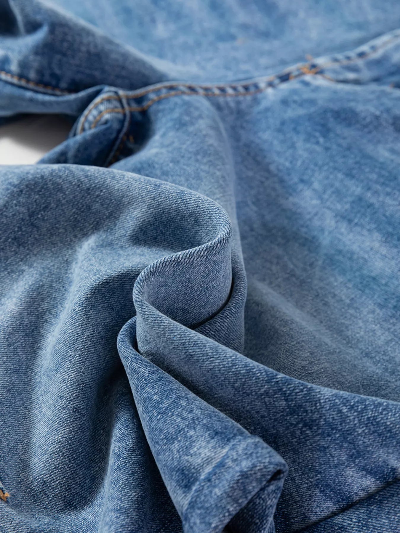 Close-up of blue denim fabric with visible stitching