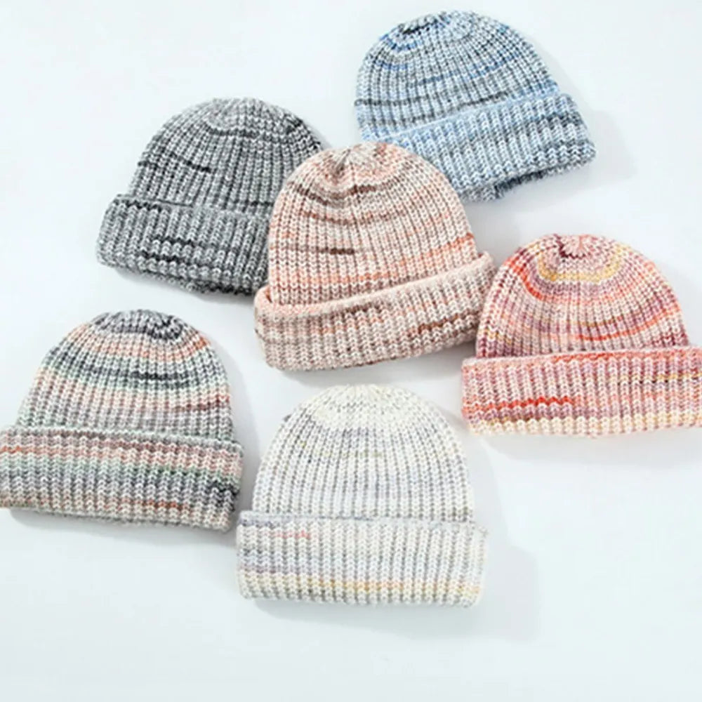 Set of knit baby hats in various colors on a light background