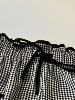 Black and white checkered fabric with a drawstring on a plain background