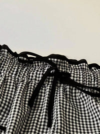 Black and white checkered fabric with a drawstring on a plain background